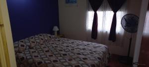 a bedroom with a bed and a window with a fan at Duplex Cuty Nakey in Puerto Madryn +3 photos