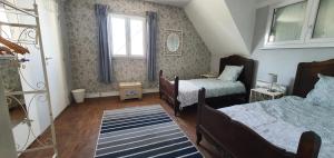 niewielka sypialnia z 2 łóżkami i oknem w obiekcie Chezshells - pres de la plage w mieście Telgruc-sur-Mer
