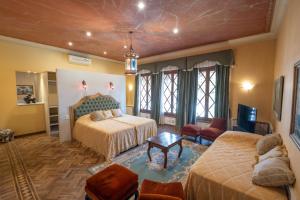 a bedroom with two beds and a living room at Augusta Palace in Salta