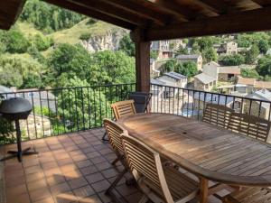 d'une table et de chaises en bois sur un balcon avec vue. dans l'établissement Atalaya - Montserrat Figueras - Gîte pour 8 personnes - 4 chambres en suite - Piscine, à Llo