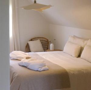 a white bed with towels on top of it at Oak Tree Cottage in Lincolnshire
