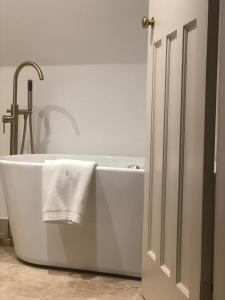 a bathroom with a bath tub with a towel on it at Oak Tree Cottage in Lincolnshire