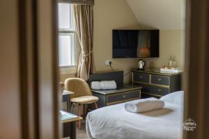 a hotel room with a bed and a desk and a tv at Burlington House Boutique in Oxford
