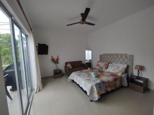 a bedroom with a bed and a couch and a ceiling fan at Ibiza Reservado 201 in Melgar