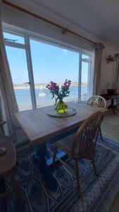 a wooden table with a vase of flowers on it at Brooklands Farm Hamble Riverside apartment on the reiver in Southampton