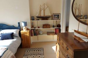 a bedroom with a bed and a dresser with a ship on it at Brooklands Farm Hamble Riverside apartment on the reiver in Southampton