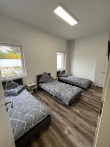 een kamer met 3 bedden en een raam bij Sam Apartments LU/Oppau in Ludwigshafen am Rhein