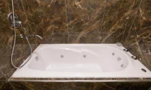 una bañera con ducha en un baño en Augusta Palace, en Salta
