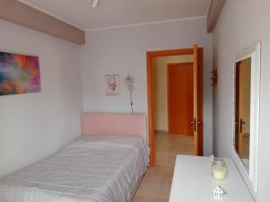 Dormitorio pequeño con cama y mesa en Belvedere Apartment en SantʼAlfio
