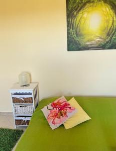 a green bed with a flower on top of it at Appartamento vicino aeroporto d'Abruzzo in San Giovanni Teatino