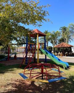 a playground with a slide in a park at Pousada Flamboyant in Olímpia