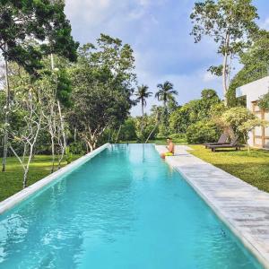 una persona sentada en el borde de una piscina en UYANA Boutique Hotel and Retreat ADULTS ONLY en Ahangama
