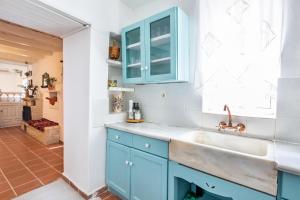 a kitchen with blue cabinets and a sink at Olive Grove Cottage in Karpathos Town