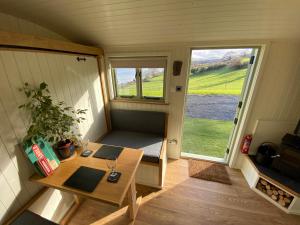 a tiny house with a table and a window at Shepherds Hut, Conwy Valley in Conwy