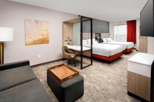 a hotel room with two beds and a couch at SpringHill Suites by Marriott Punta Gorda Harborside in Punta Gorda