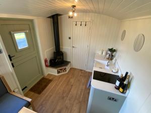 a small kitchen with a sink and a stove at Shepherds Hut, Conwy Valley in Conwy