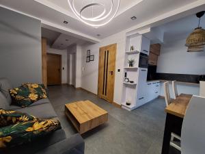 een woonkamer met een bank en een tafel bij Apartament NATA in Zakopane