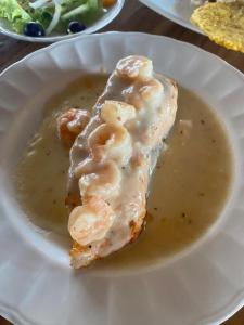 a white plate with a piece of shrimp with sauce at Ecohotel La Reserva in Piojó