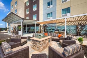 eine Terrasse mit Stühlen und einer Feuerstelle vor einem Gebäude in der Unterkunft TownePlace Suites by Marriott Owensboro in Owensboro