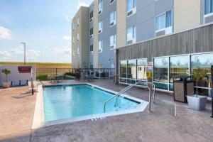 uma piscina em frente a um edifício em TownePlace Suites by Marriott Owensboro em Owensboro
