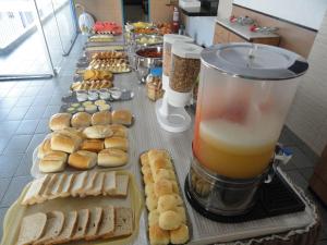 a buffet of pastries and a drink on a table at Pousada São Luiz in Aracaju