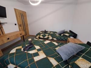 een slaapkamer met 2 aparte bedden en een tafel bij Apartament NATA in Zakopane