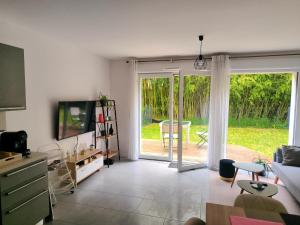 a living room with a sliding glass door at Superbe appartement avec jardin in Courrejean