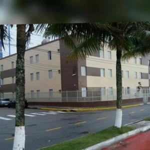 due palme di fronte a un edificio di Apartamento no edifício Abaeté a Mongaguá