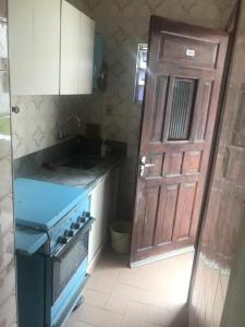 a kitchen with a door and a sink and a stove at Apartamento no edifício Abaeté in Mongaguá