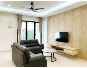 a living room with a couch and a tv at Pangkor Villa88 Double Storey 3min to Pasir Bogak Beach in Pangkor