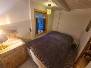 a small bedroom with a bed and a window at Hyggeligt gammelt hus i Vestmanna in Vestmanna