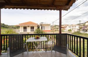 a table with a bowl of fruit on a balcony at Tsimiklis Apartments in Finikounta