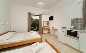 a small bedroom with a bed and a kitchen at Tsimiklis Apartments in Finikounta