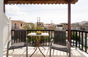 a table and two chairs on a balcony at Tsimiklis Apartments in Finikounta