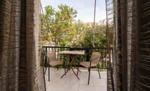 patio con mesa y sillas en el balcón en Tsimiklis Apartments, en Finikounta
