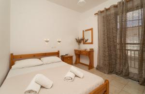 a bedroom with a bed with two towels on it at Tsimiklis Apartments in Finikounta