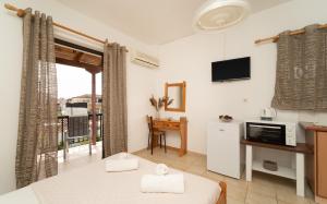a living room with a large window and a tv at Tsimiklis Apartments in Finikounta