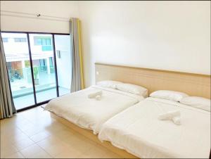 two beds in a room with a large window at Pangkor Villa88 Double Storey 3min to Pasir Bogak Beach in Pangkor