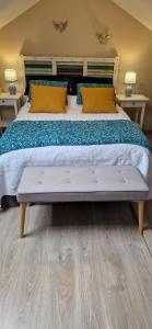 Les Cormiers في Cangey: غرفة نوم بسرير كبير مع أرضية خشبية