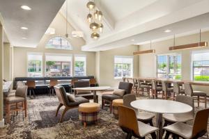 a waiting room with tables and chairs and windows at Residence Inn by Marriott Palmdale Lancaster in Palmdale