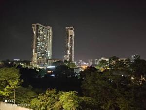 a city skyline at night with two tall buildings at HP402- Two Bedroom Apartment- Wifi- Netflix- Parking- Cyberjaya -New, 3061 in Cyberjaya