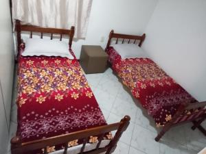 duas camas sentadas uma ao lado da outra num quarto em Hostel Da Penha em Vila Velha