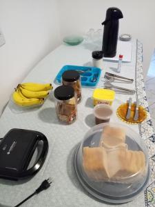 uma mesa com um prato de comida e bananas em Hostel Da Penha em Vila Velha