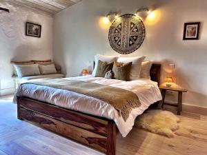 um quarto com uma cama grande e um relógio na parede em Maison Marie em Lagarde