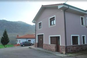 una casa blanca con un coche aparcado delante de ella en Casa Balbi, en Canales
