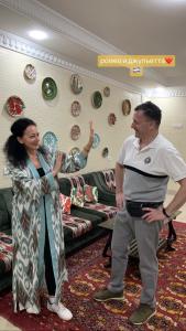 un hombre y una mujer de pie en una sala de estar en Hotel Saidkasim with a Terrace, en Bukhara