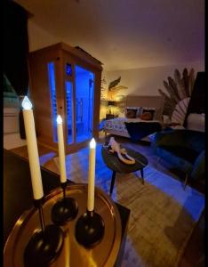 - un salon avec trois bougies sur une table dans l'établissement Escapade Mâconnaise Spa-Sauna-Ciel de pluie tropicale-Champagne Nuit Romantique, à Mâcon