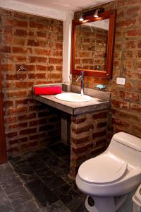 a bathroom with a white toilet and a sink at Comunidad La Moya, Calpi in Riobamba