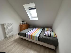 małą sypialnię z łóżkiem z oknem w obiekcie Breizh Horizon w mieście Tréméven