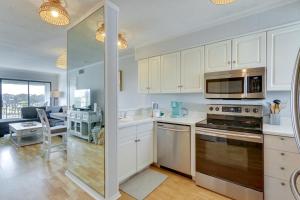 a kitchen with white cabinets and a living room at Walk to Beach Hilton Head Condo with Golf Views in Hilton Head Island